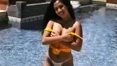 Janice shows her nice little ass as she poses and teases in the pool